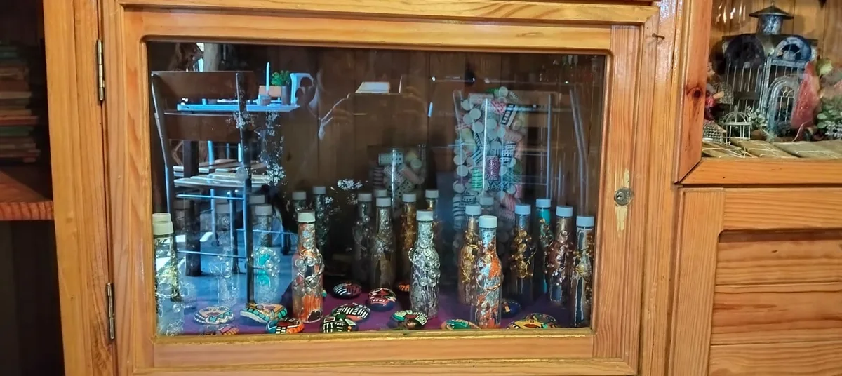 Vitrina con botellas artesanales y piedras pintadas